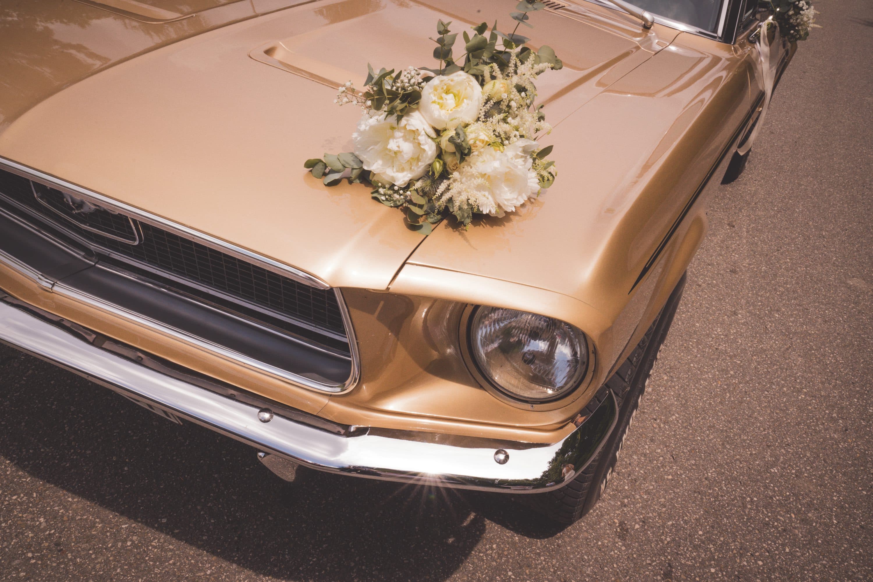 White wedding bouquet placed on a bronze vintage car hood