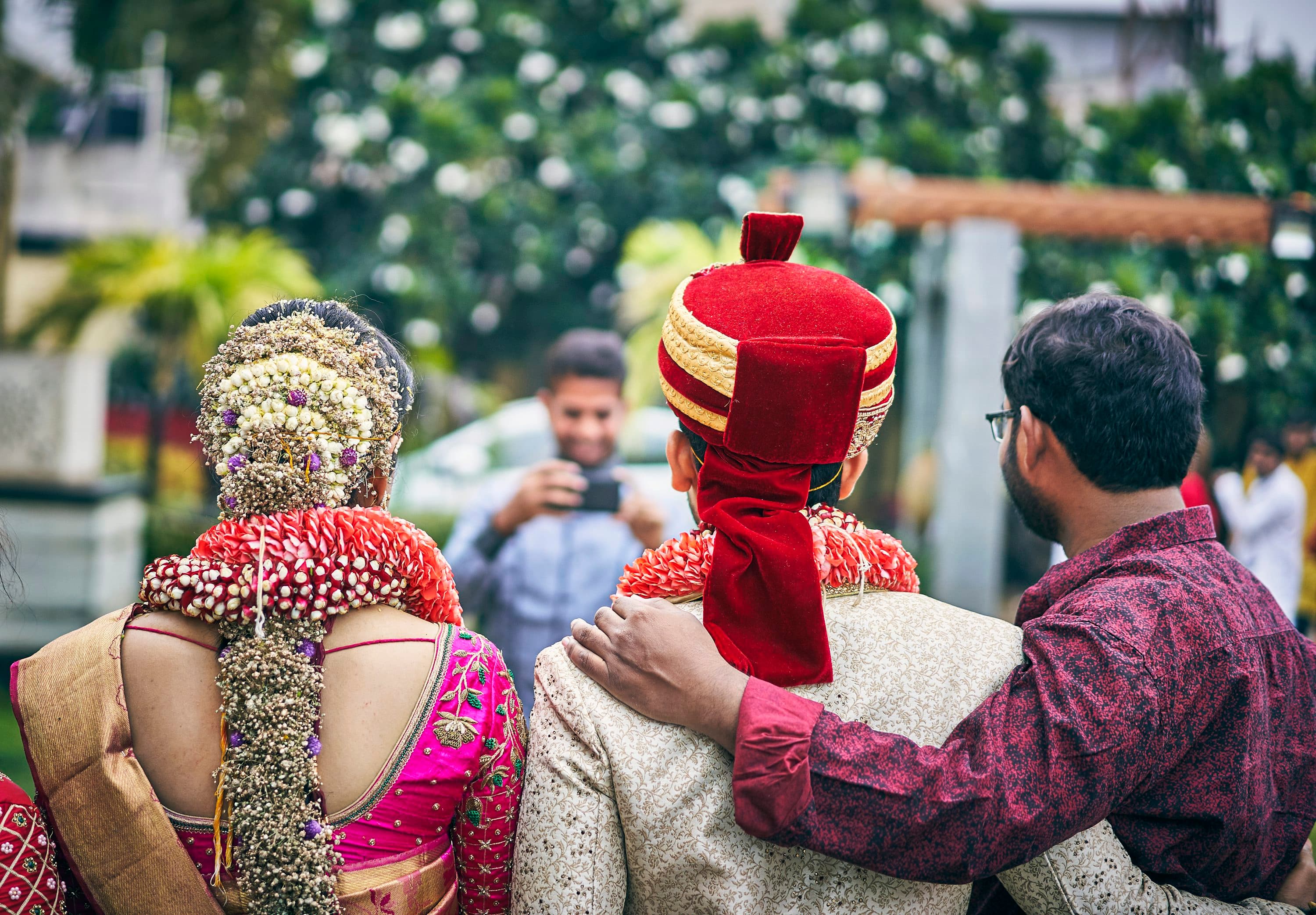 Wedding coordinator guiding a bride and groom during their car movement